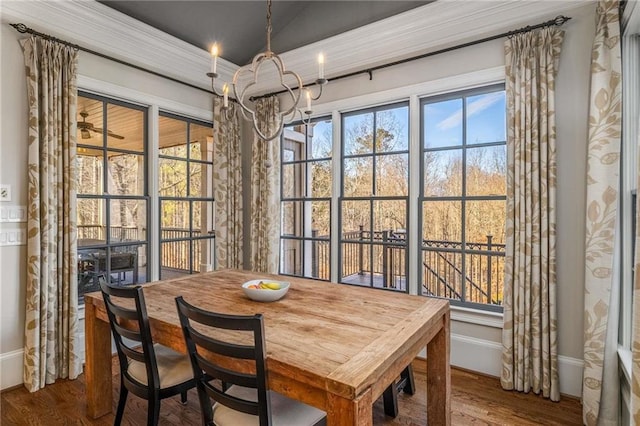 dining space featuring a chandelier, baseboards, and wood finished floors