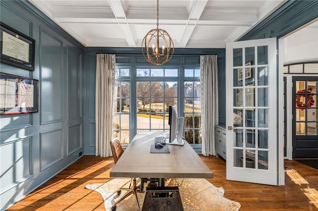 office featuring beam ceiling, coffered ceiling, wood finished floors, a decorative wall, and a chandelier