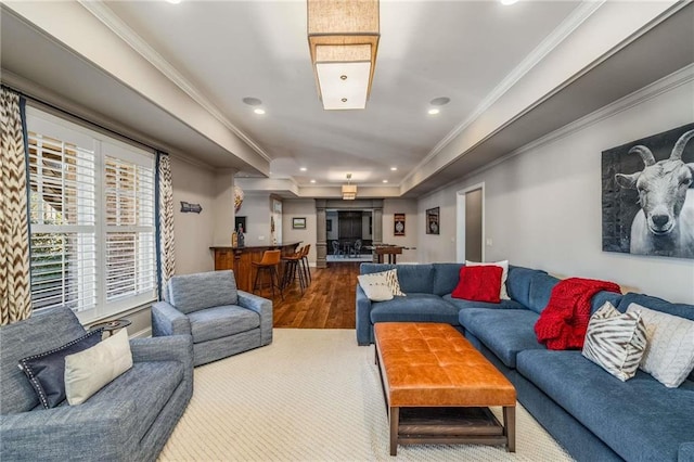 living room with recessed lighting, a raised ceiling, crown molding, and wood finished floors