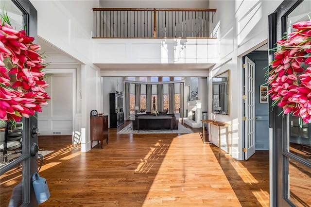 foyer entrance with a towering ceiling and wood finished floors