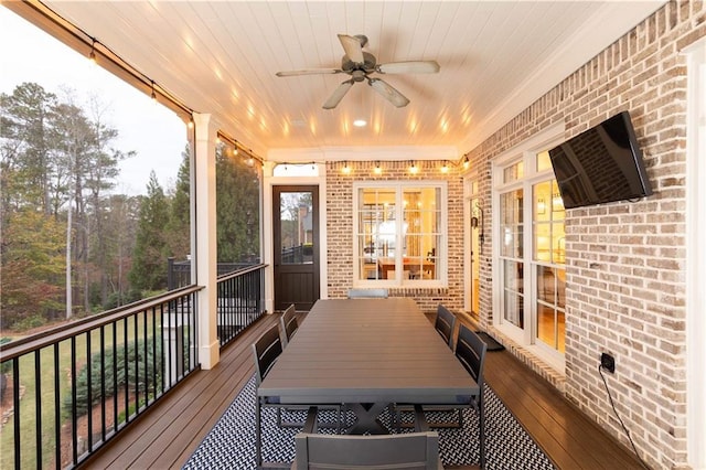 unfurnished sunroom with a ceiling fan, wooden ceiling, and a healthy amount of sunlight