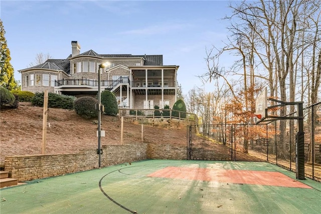 view of basketball court featuring stairs, community basketball court, and fence