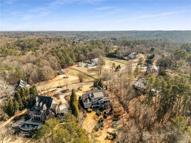 bird's eye view with a wooded view