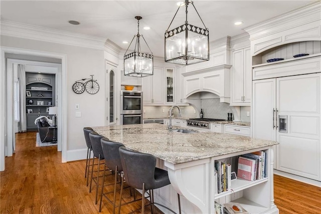 kitchen featuring open shelves, a sink, wood finished floors, white cabinetry, and stainless steel appliances