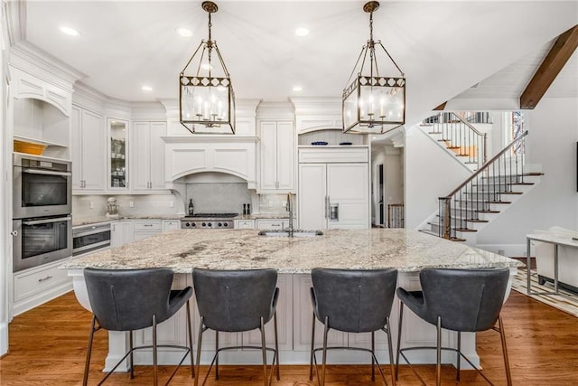 kitchen with double oven, paneled built in fridge, dark wood-style flooring, and a sink