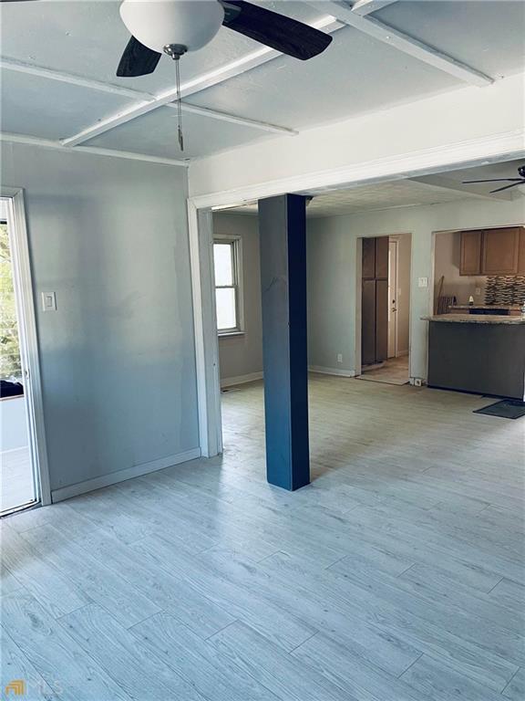 empty room with ceiling fan and light wood-type flooring