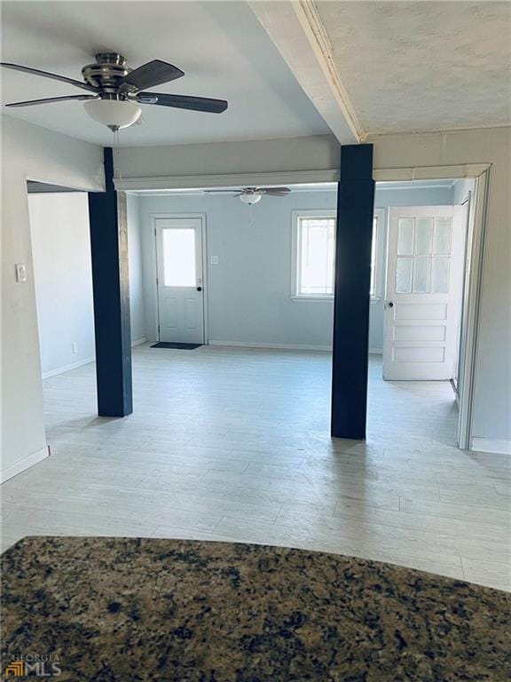 spare room featuring ceiling fan, a healthy amount of sunlight, and light wood-type flooring