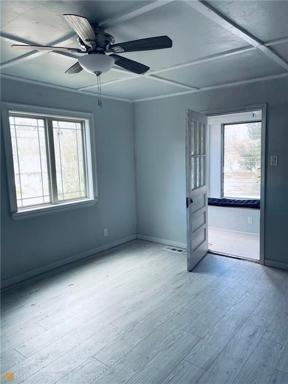 spare room with ceiling fan, a wealth of natural light, and light wood-type flooring