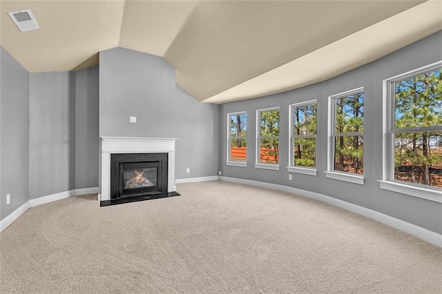 unfurnished living room featuring carpet, a fireplace with flush hearth, visible vents, vaulted ceiling, and baseboards