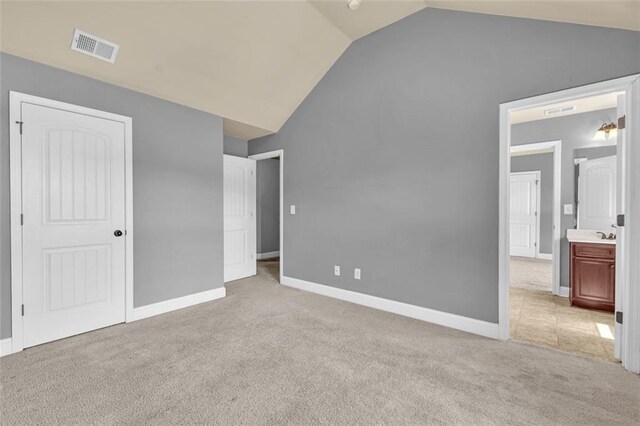 unfurnished bedroom featuring visible vents, baseboards, vaulted ceiling, and carpet floors