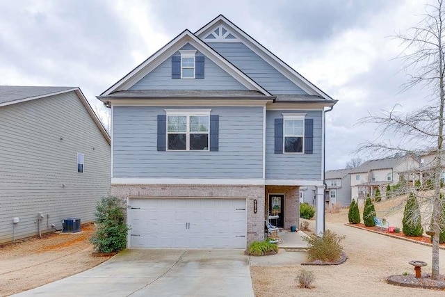 craftsman-style house featuring an attached garage, central air condition unit, driveway, and brick siding