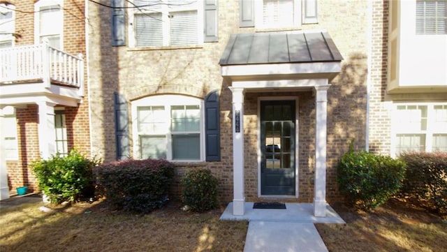 entrance to property featuring brick siding, metal roof, and a standing seam roof