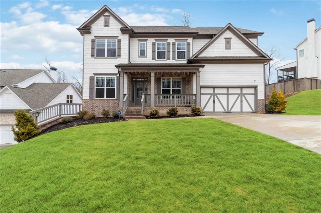 craftsman inspired home with a porch, a garage, and a front lawn