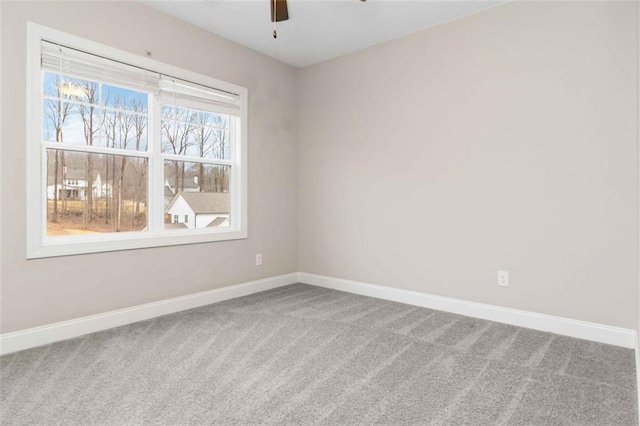 carpeted spare room featuring ceiling fan