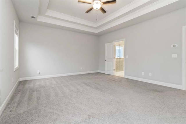 spare room with crown molding, a tray ceiling, ceiling fan, and carpet flooring