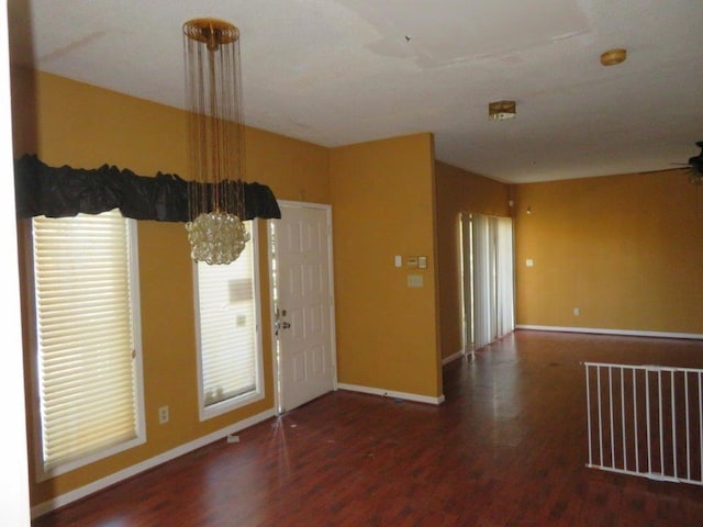 entrance foyer with baseboards, visible vents, dark wood finished floors, and a notable chandelier