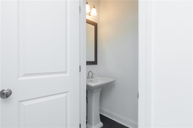 bathroom featuring baseboards and a sink