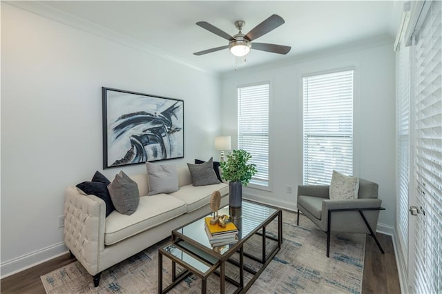 living room with baseboards, wood finished floors, ceiling fan, and ornamental molding