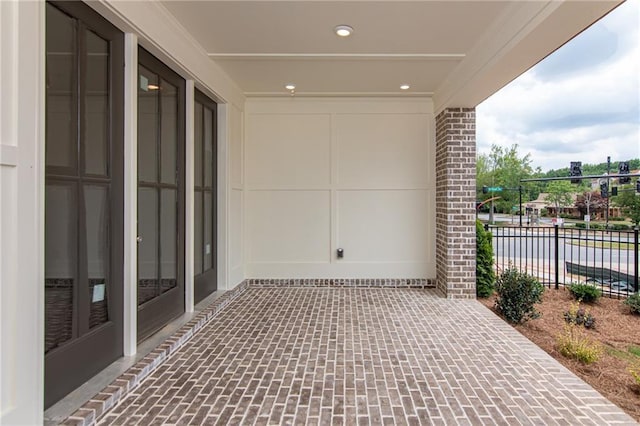 view of patio with fence and a water view