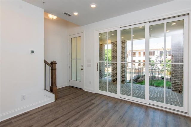 entryway featuring wood finished floors, baseboards, recessed lighting, and stairs