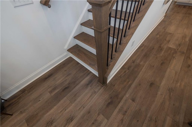 staircase featuring baseboards and wood finished floors