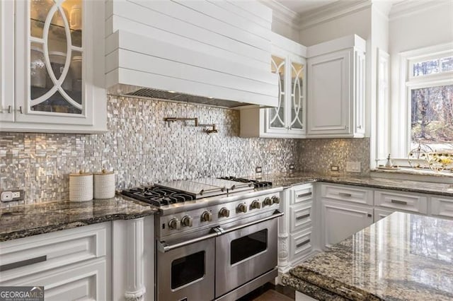 2616 Boddie Pl, Duluth, GA 30097 - kitchen with range with two ovens, tasteful backsplash, white cabinets, glass insert cabinets, and custom range hood