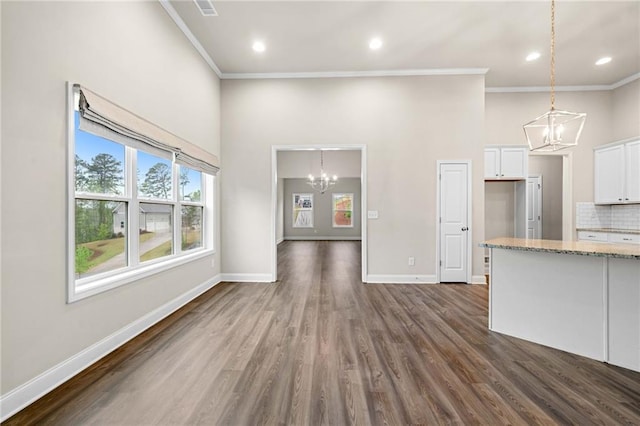 8230 Dawson View Way, Cumming, GA 30028 - unfurnished living room with crown molding, baseboards, a notable chandelier, and dark wood finished floors