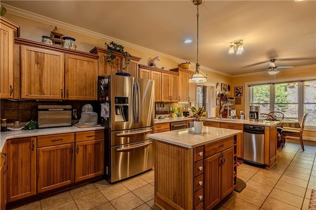 kitchen featuring decorative light fixtures, appliances with stainless steel finishes, light tile patterned flooring, and a kitchen island