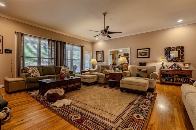 living room with light wood-type flooring, ceiling fan, and ornamental molding