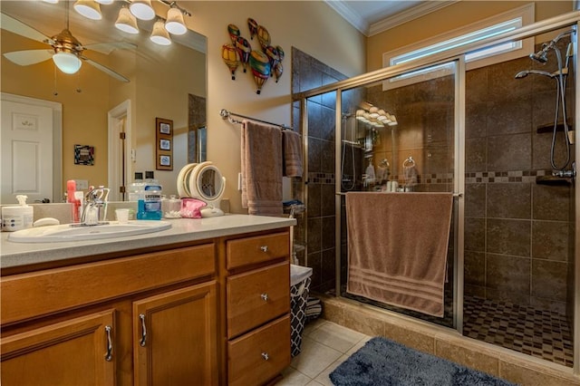 bathroom featuring a shower with shower door, ceiling fan, tile patterned flooring, crown molding, and vanity