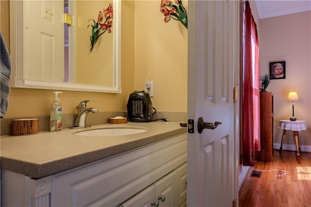 bathroom featuring hardwood / wood-style floors, vanity, and crown molding