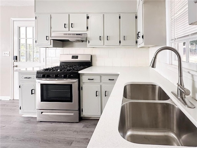 kitchen with stainless steel range with gas cooktop, white cabinetry, and sink