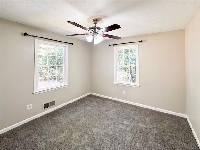 spare room with ceiling fan, plenty of natural light, and carpet floors