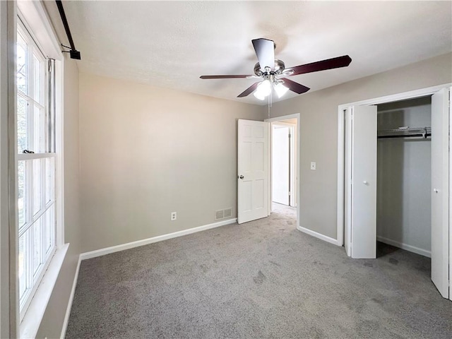 unfurnished bedroom with ceiling fan, a closet, and carpet floors