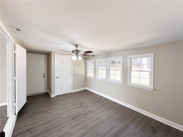 unfurnished room featuring dark wood-type flooring, ceiling fan, and a wealth of natural light