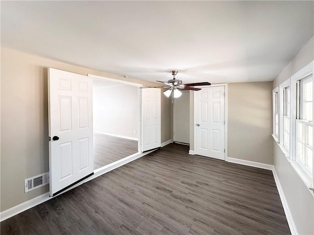 unfurnished bedroom featuring ceiling fan and dark wood-type flooring