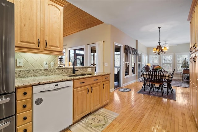 kitchen featuring sink, stainless steel fridge, dishwasher, an inviting chandelier, and light brown cabinetry