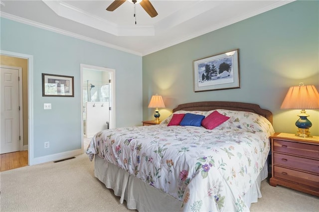 carpeted bedroom with ceiling fan, ornamental molding, connected bathroom, and a raised ceiling