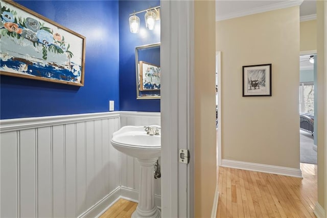 bathroom with hardwood / wood-style flooring and crown molding