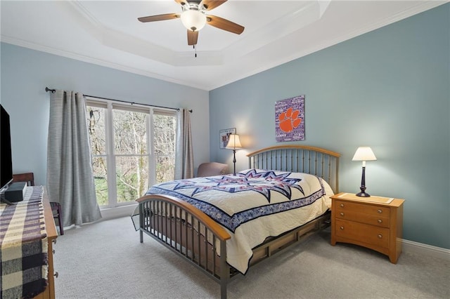 carpeted bedroom featuring crown molding, ceiling fan, and a tray ceiling