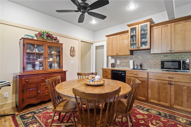 kitchen featuring dark wood-type flooring, sink, tasteful backsplash, dishwasher, and ceiling fan