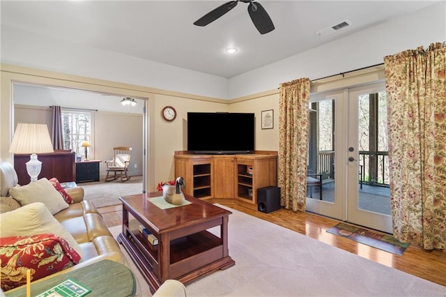 living room featuring french doors, ceiling fan, and light hardwood / wood-style flooring