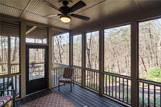 unfurnished sunroom featuring ceiling fan and a healthy amount of sunlight