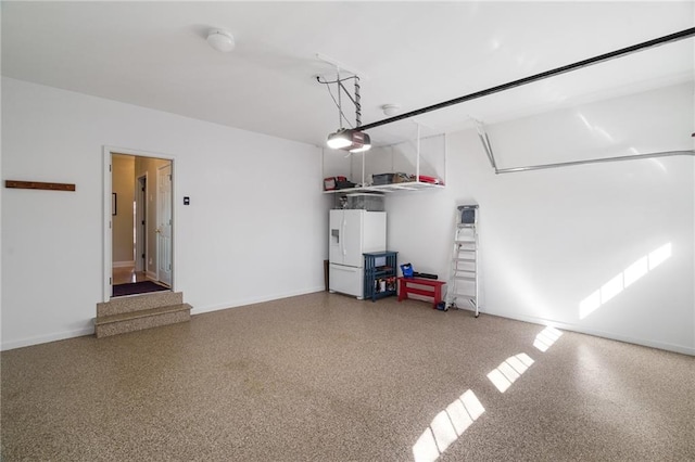 garage with a garage door opener and white fridge with ice dispenser