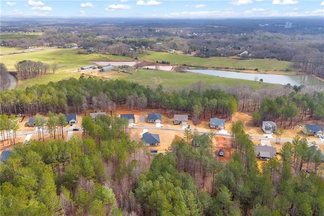 aerial view featuring a forest view and a water view