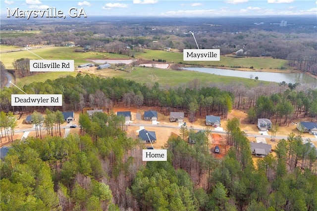 bird's eye view featuring a wooded view and a water view