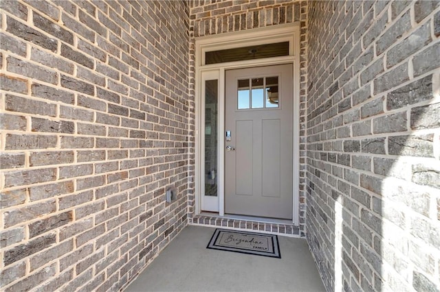 property entrance featuring brick siding