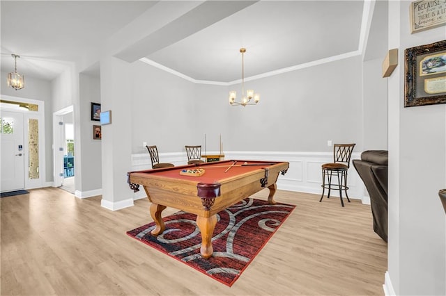 game room with crown molding, a notable chandelier, light wood finished floors, and wainscoting