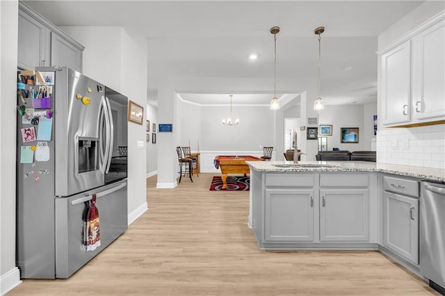 kitchen with tasteful backsplash, gray cabinetry, stainless steel appliances, and light wood-type flooring