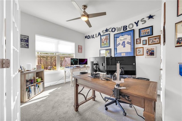 home office featuring carpet flooring, ceiling fan, and baseboards